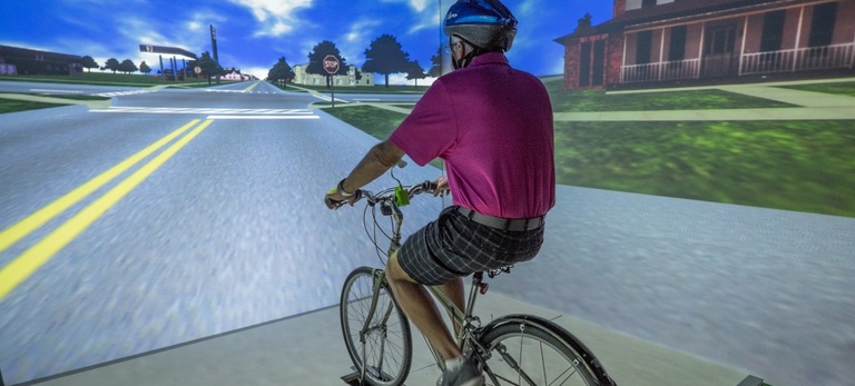 person with helmet riding on bike in simulator